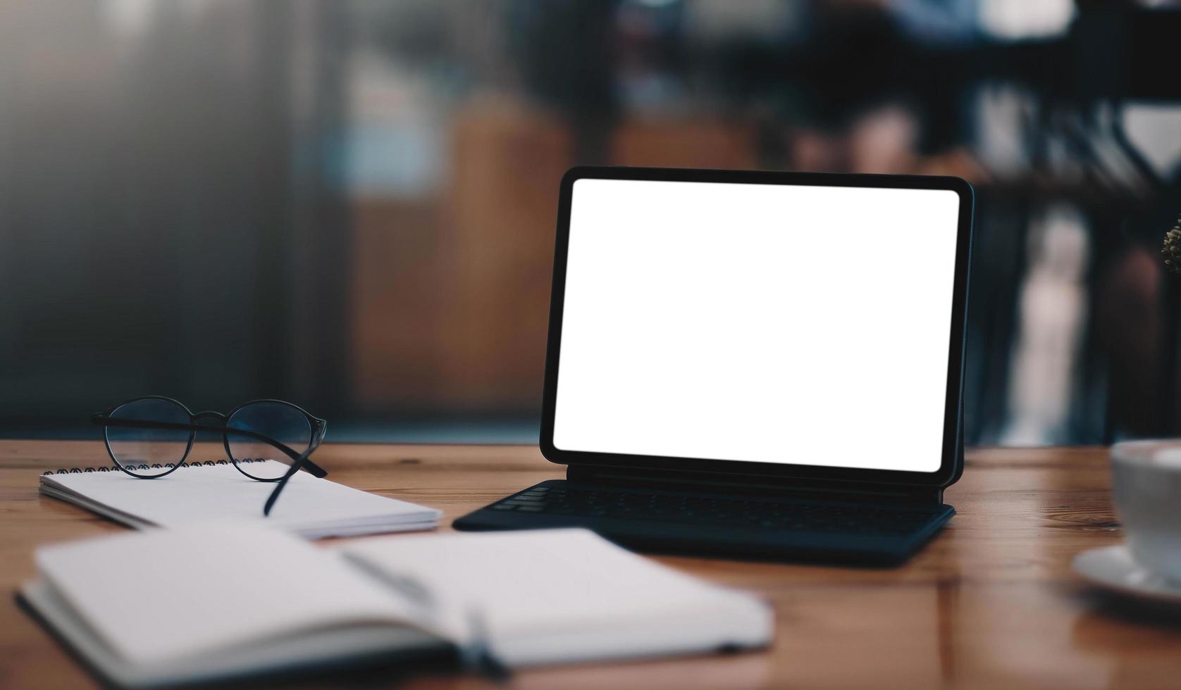 Close-up view of open blank screen laptop computer with office photo