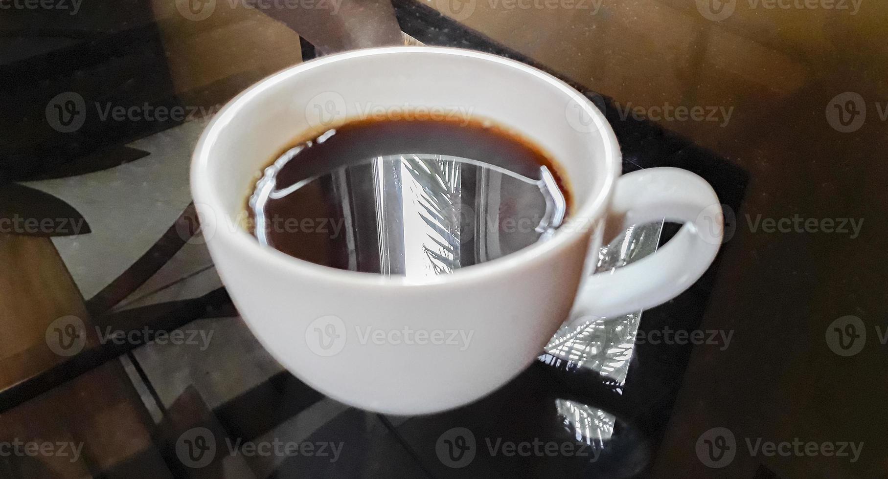 Crema de café negro en taza blanca sobre mesa negra Laos. foto