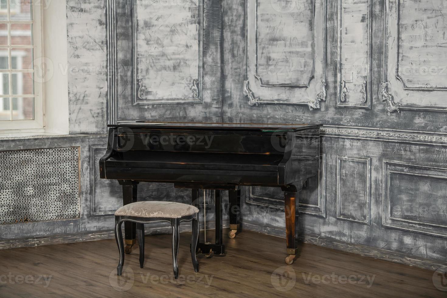 An old retro grand piano stands in the room. photo