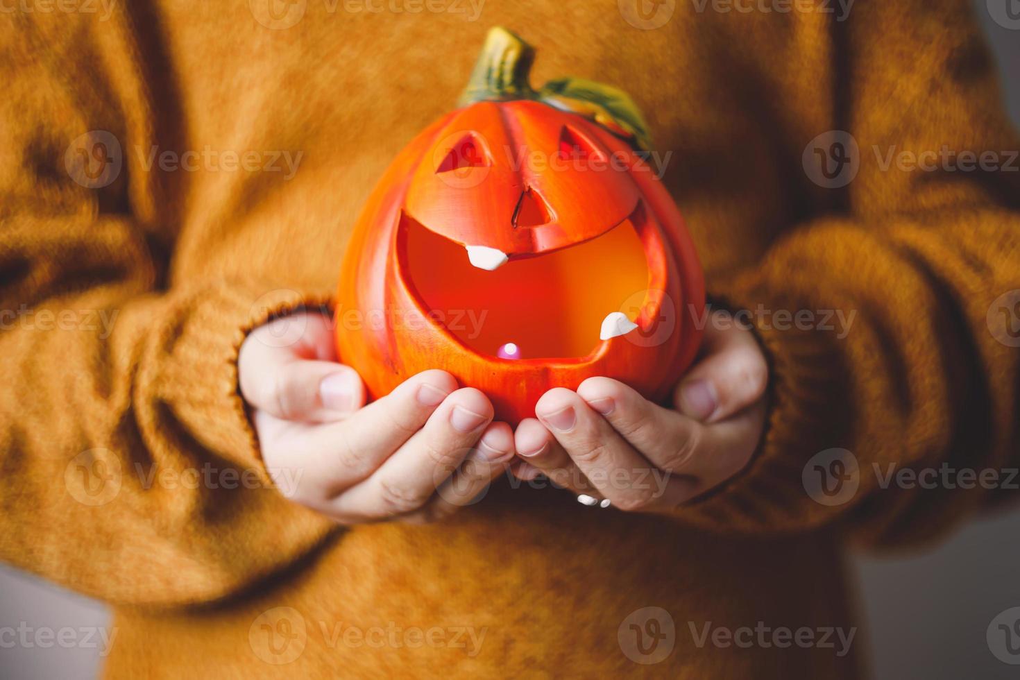 Lámpara de calabaza de Halloween en manos de los niños. foto