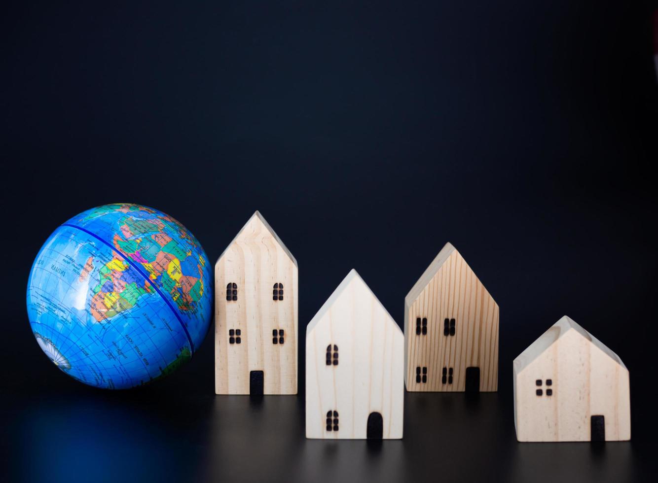 Model wooden houses and miniature globes Blank on a black background. photo