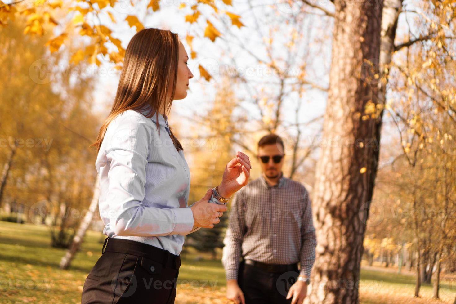 Hombre desconocido con gafas de sol mira a una mujer en el parque foto