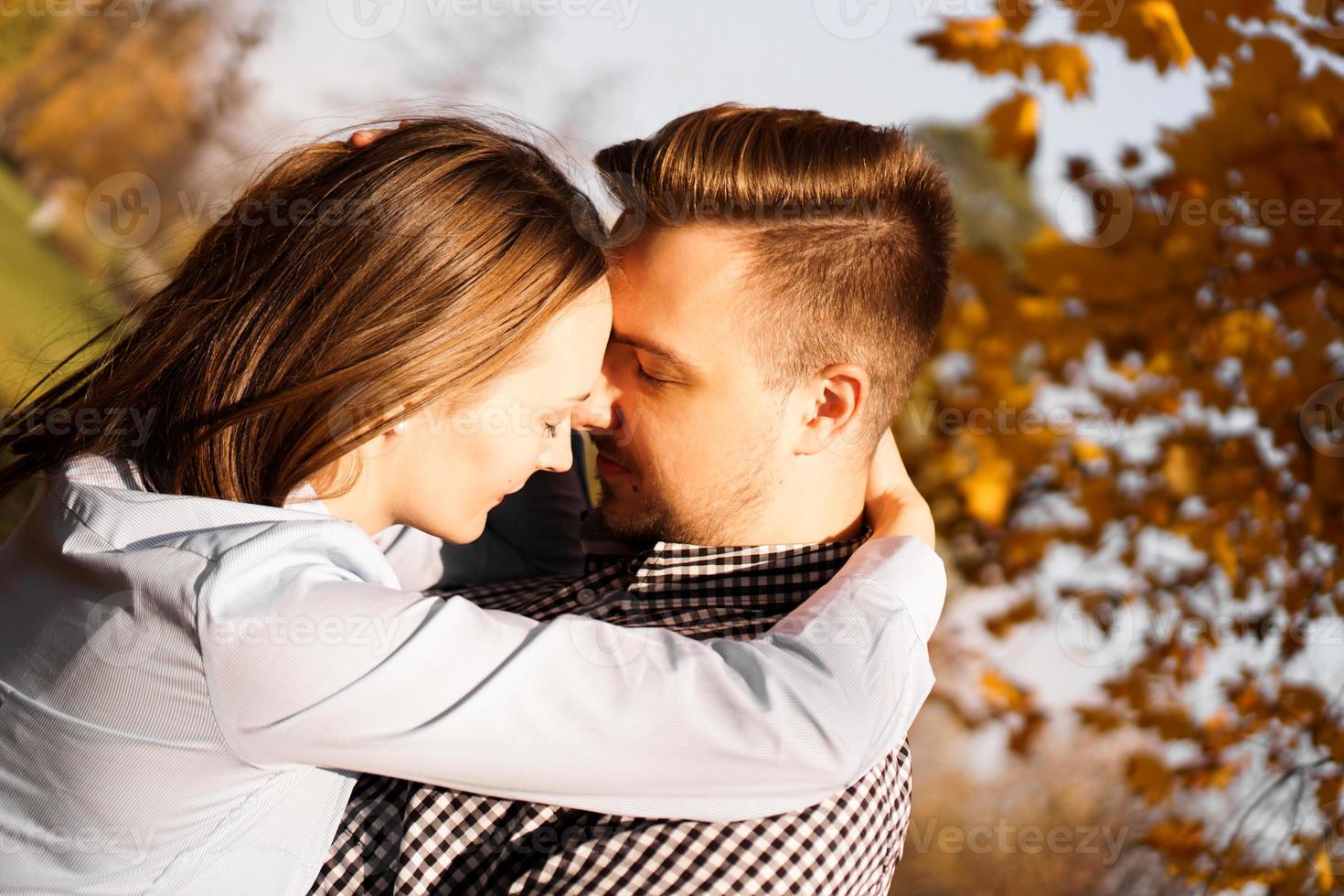 Pareja romántica en el parque de otoño - concepto de amor, relación y citas foto