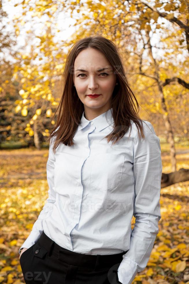 Portrait of beautiful young woman in autumn park photo