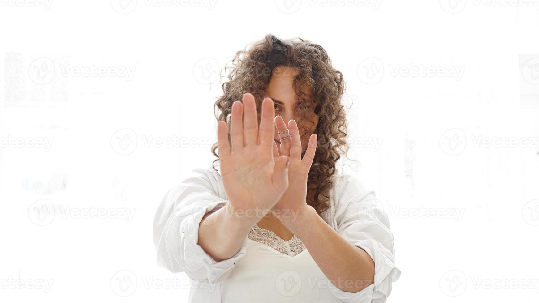 Woman making stop gesture with her hand isolated on a white background photo