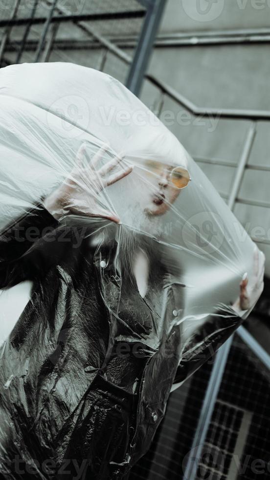 Ecology concept. Girl with plastic wrap. City Style. photo