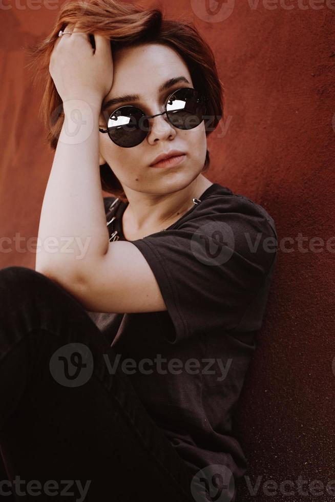 Portrait of attractive cheeky woman with short red hair in sunglasses photo