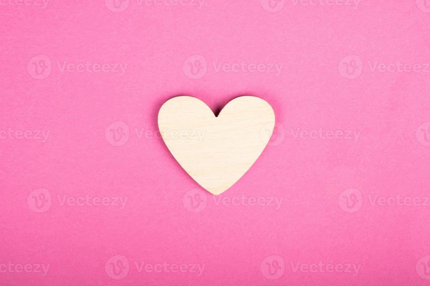 wooden heart on pink background, valentines day love symbol photo