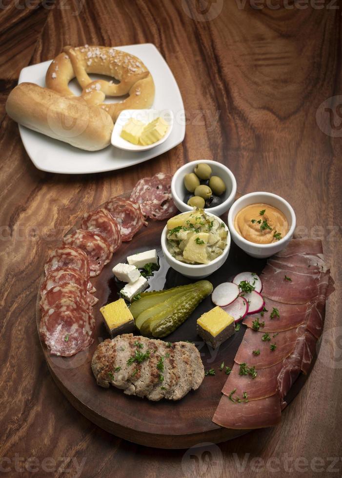 Plato de aperitivos de tapas de embutidos alemanes con carnes y pan foto