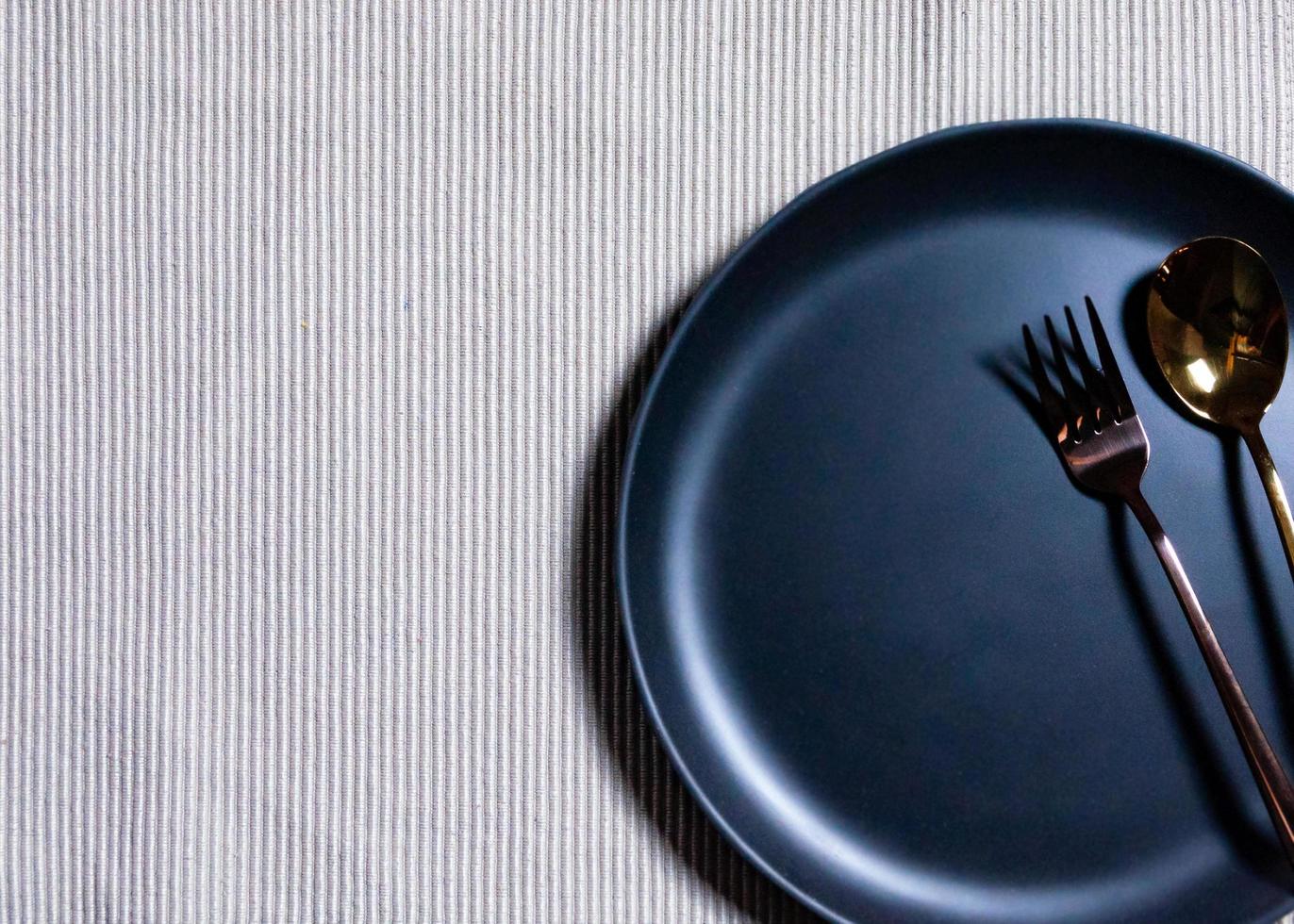 Empty plate with spoon and fork on Napery background, table setting photo