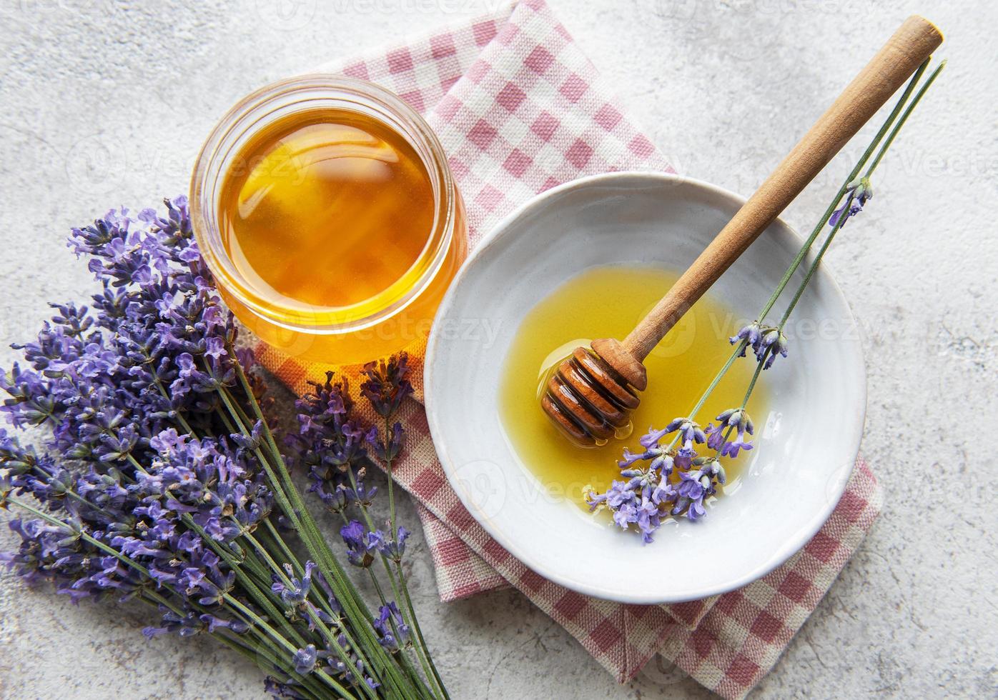 tarro con miel y flores frescas de lavanda foto