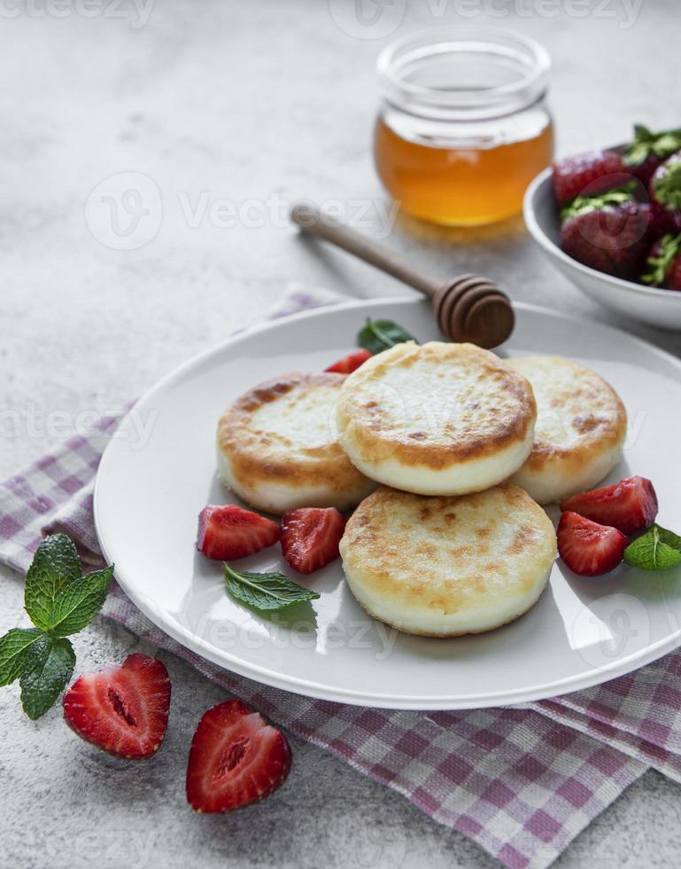 Cottage cheese pancakes, ricotta fritters on ceramic plate photo