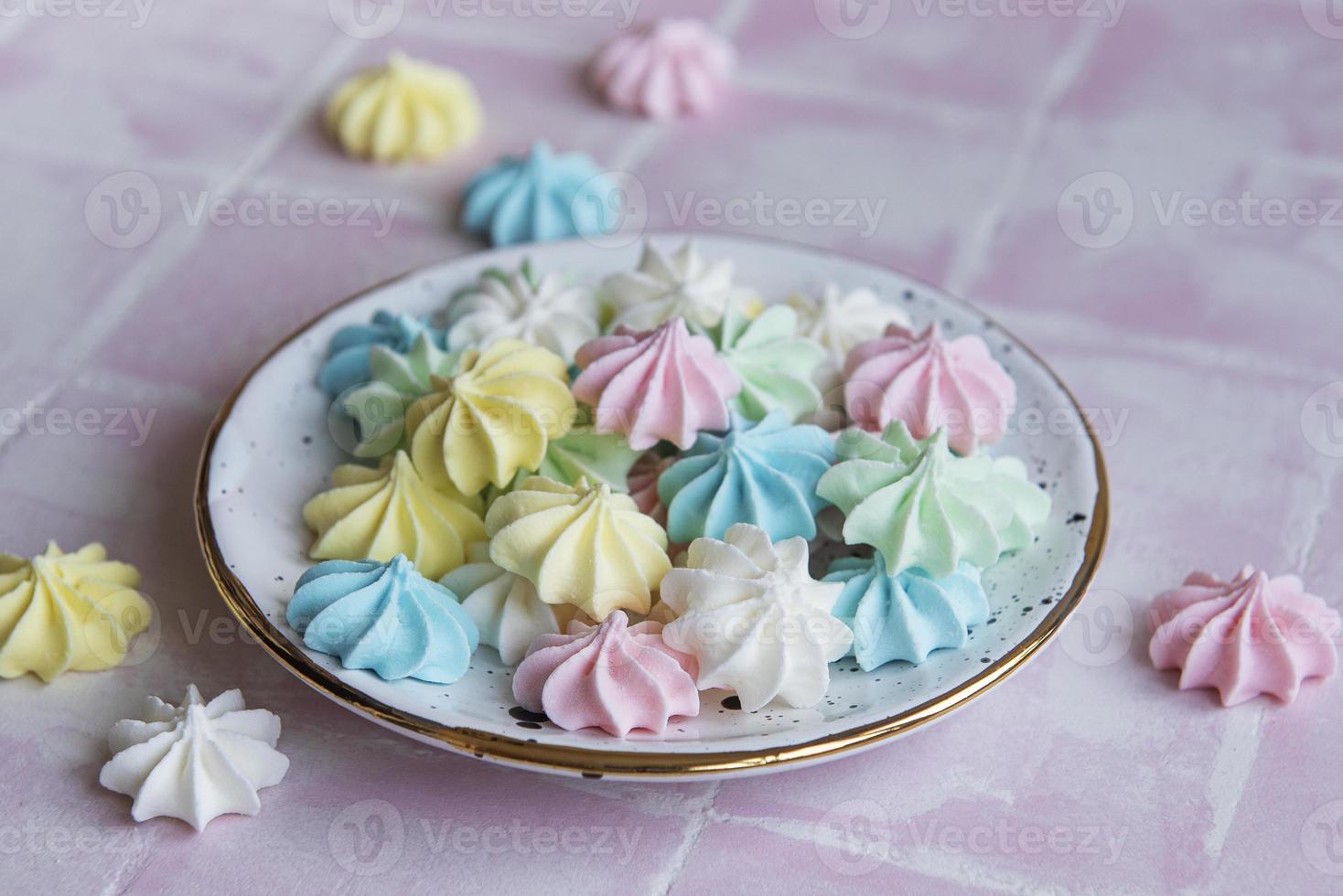 pequeños merengues de colores en el plato de cerámica foto