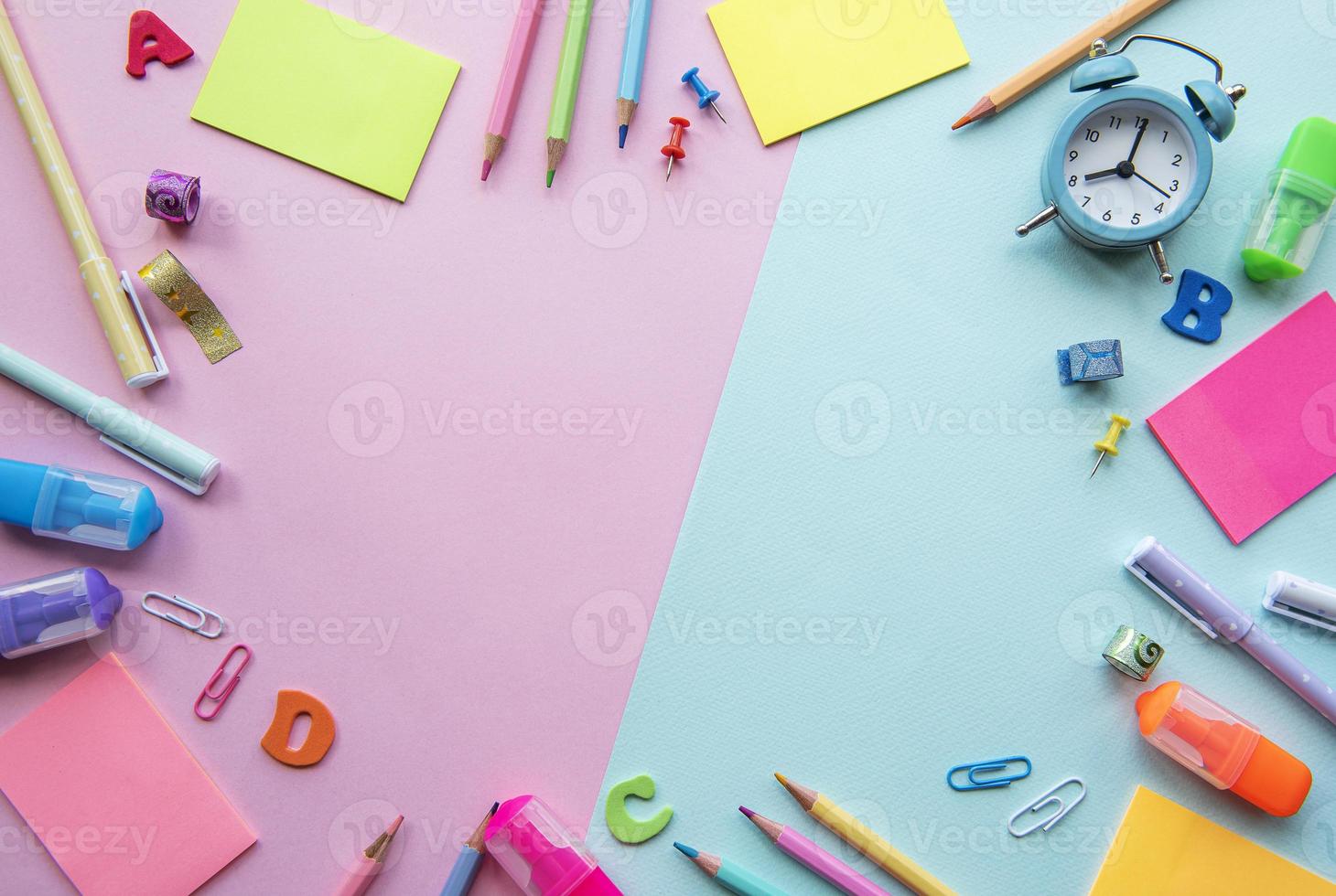 Bastidor de diferentes artículos de papelería sobre fondo rosa y azul. foto