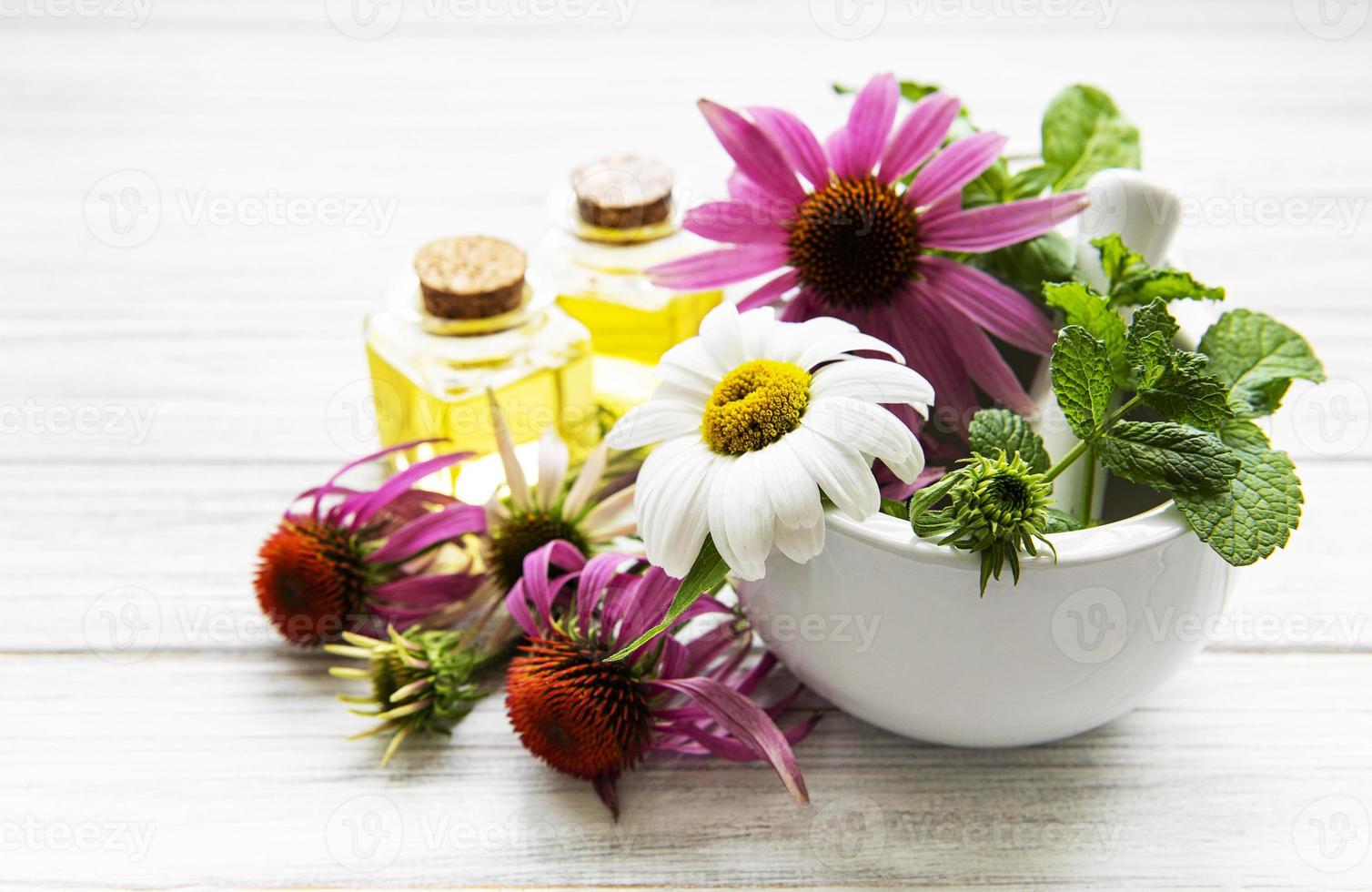 flores y plantas medicinales en mortero y aceites esenciales foto