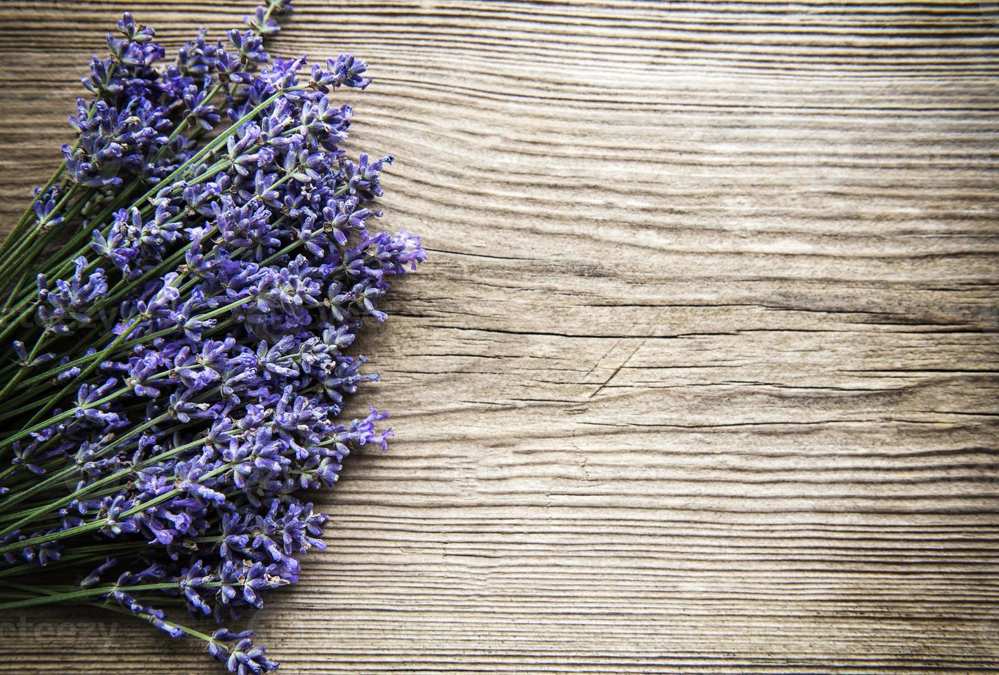 Fresh flowers of lavender bouquet, top view on old wooden background photo