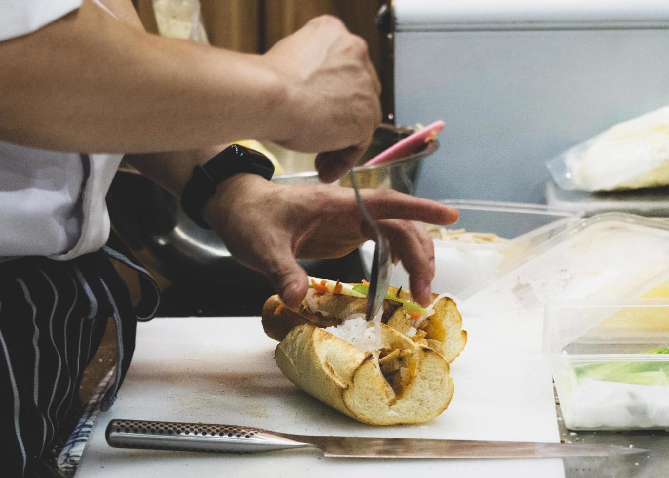 chef prepara sándwich en la cocina foto
