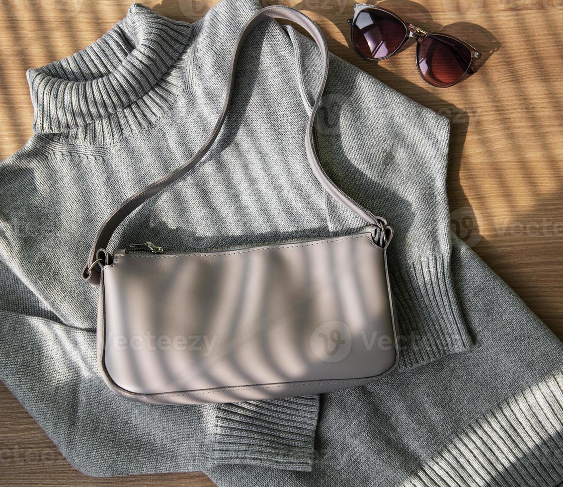 pequeño bolso de piel beige y jersey de mujer gris foto