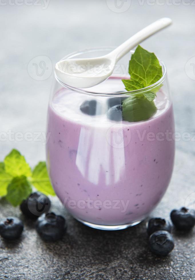 Glass of blueberry yogurt with blueberries photo