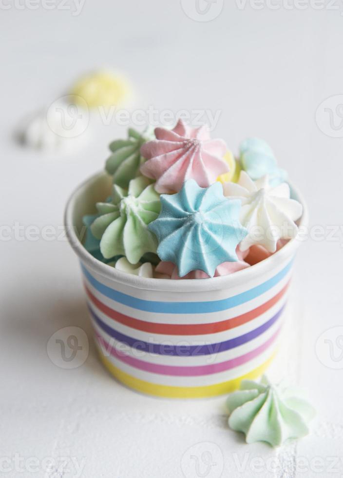 Small colorful meringues in the  paper bowl photo