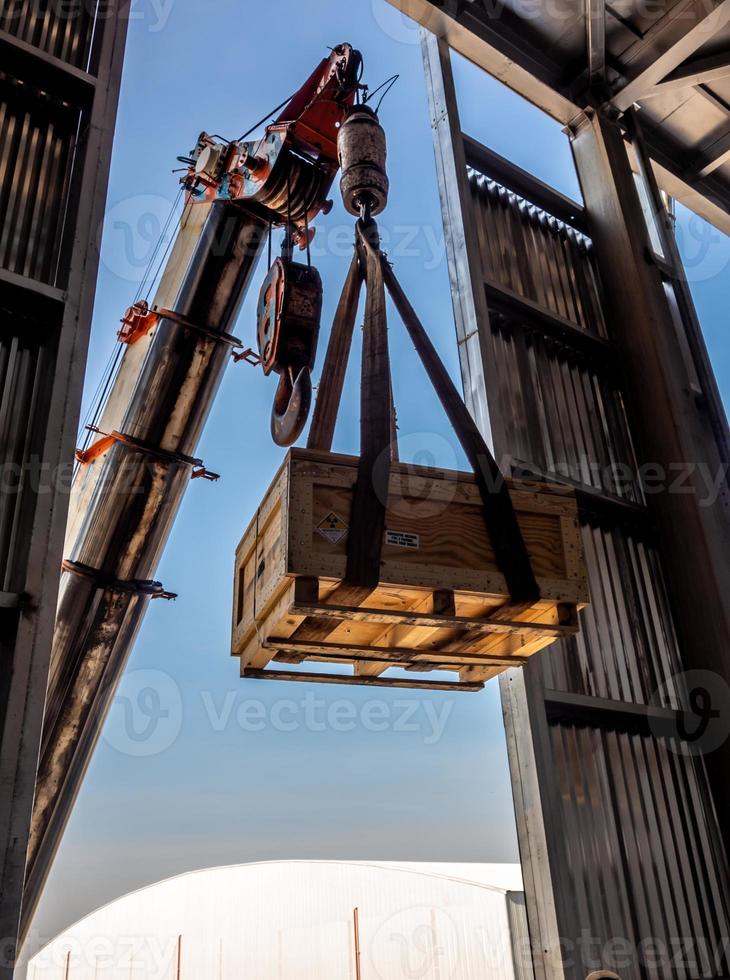 The crane carrying a wooden box of radioactive package to the plant photo