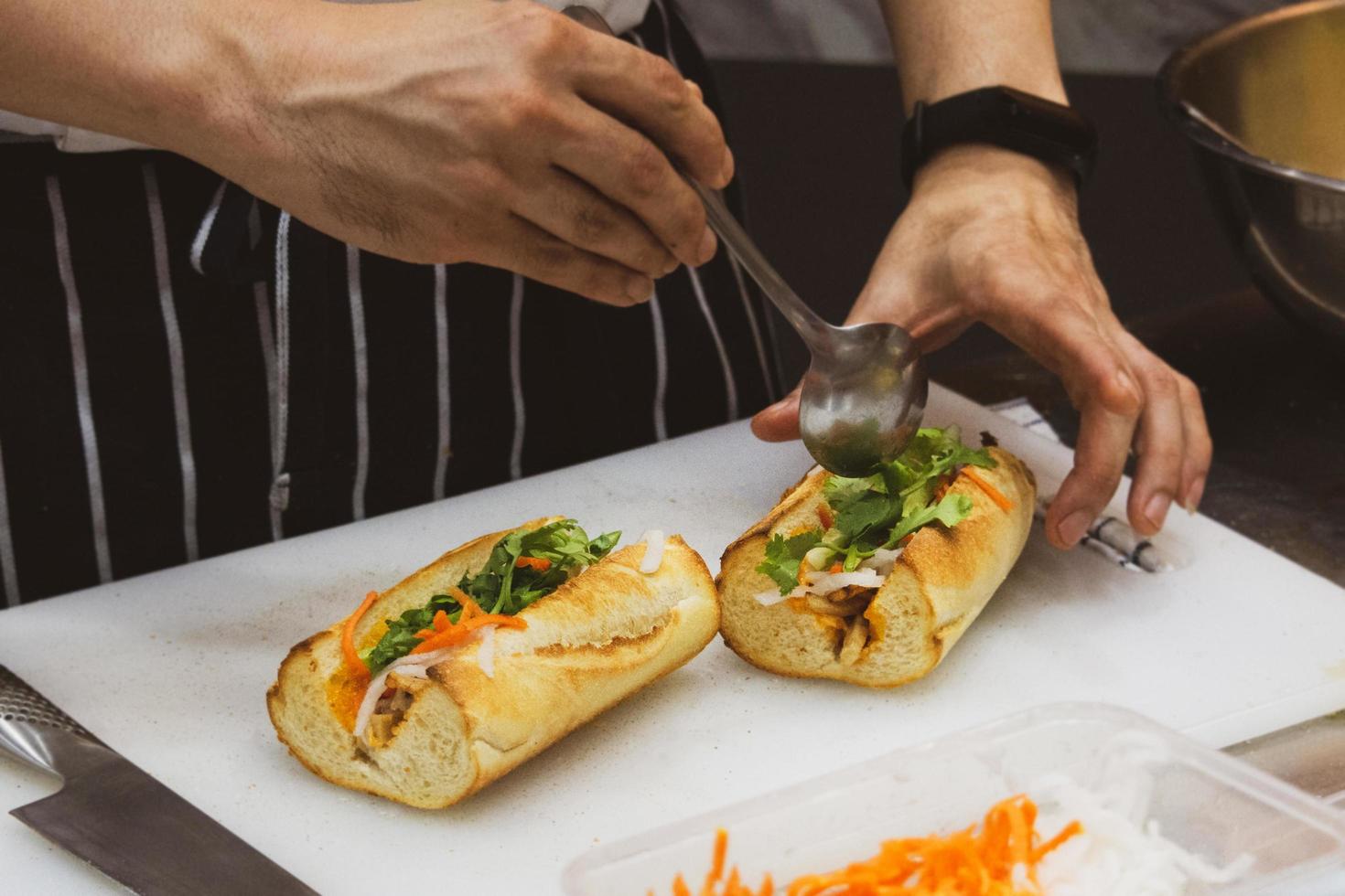 chef prepara sándwich en la cocina foto