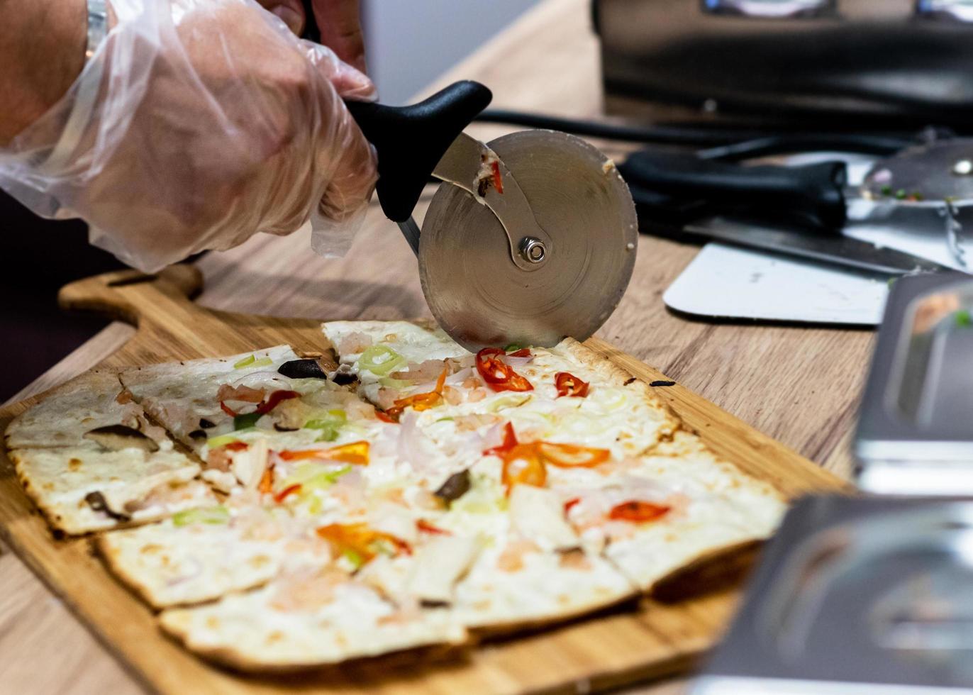 Deliciosa pizza fresca, primer plano de cortador de pizza en pizza italiana foto