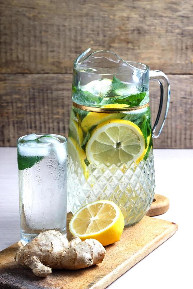 agua de frutas con limón, pepino y menta en jarra de vidrio foto