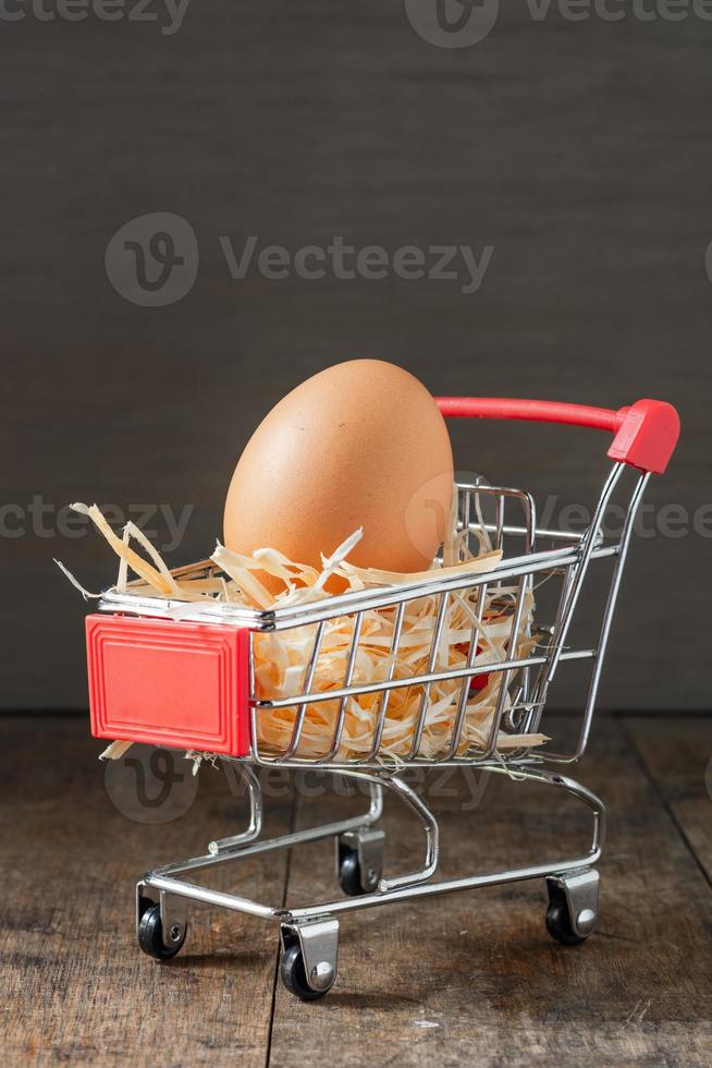 Fresh Organic eggs with dry grass on the grocery shopping cart photo