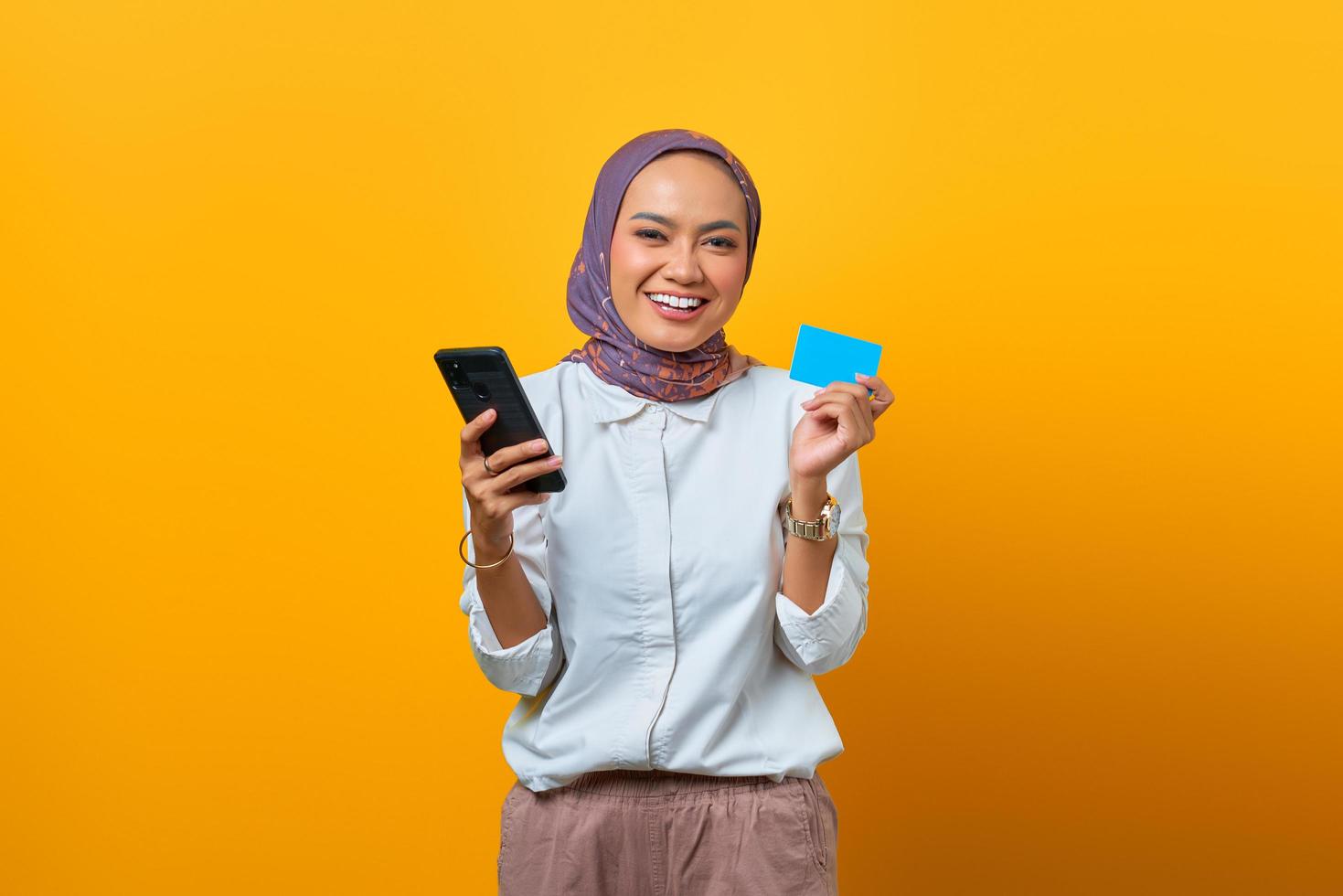 alegre, mujer asiática, tenencia, smartphone, y, actuación, tarjeta en blanco foto