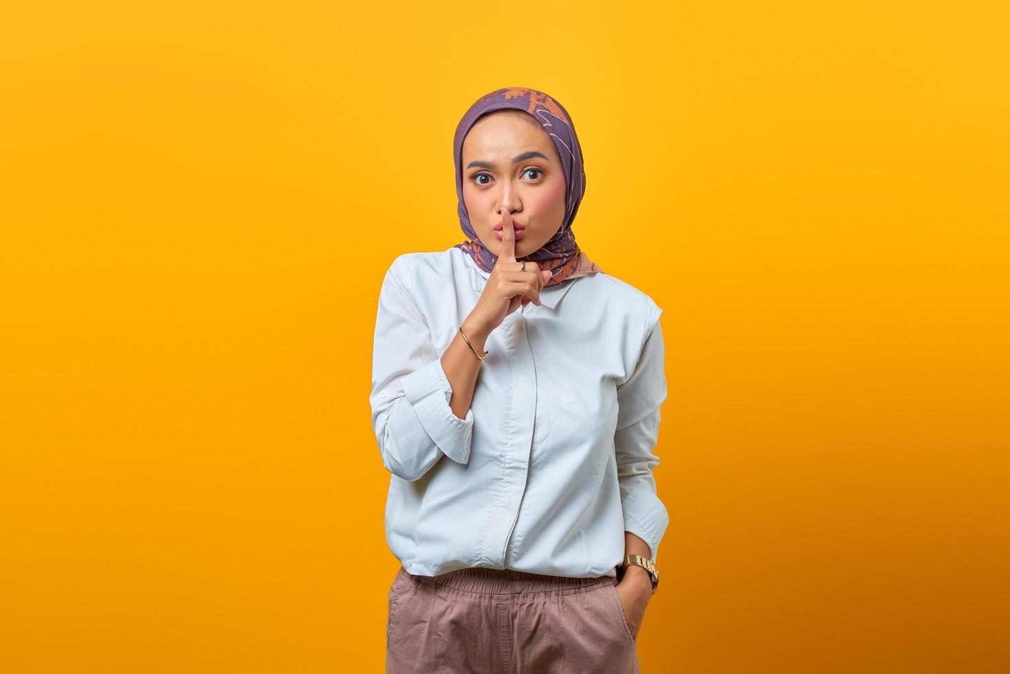 Hermosa mujer asiática haciendo el dedo en los labios boca gesto silencioso silencioso foto