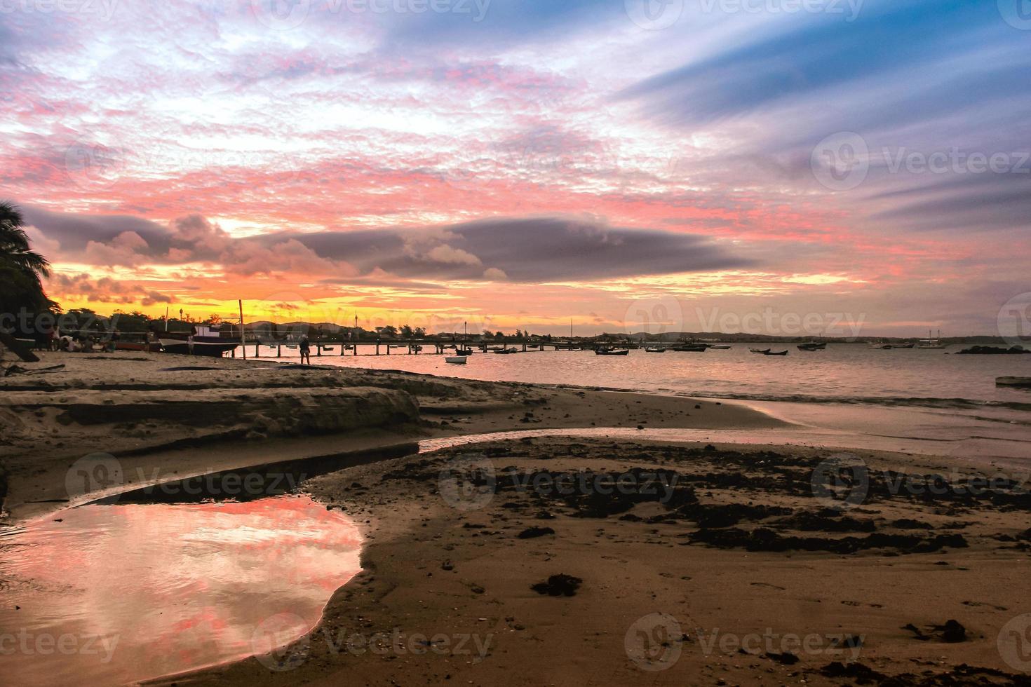 puesta de sol en el muelle, los colores del cielo se reflejan en el agua foto