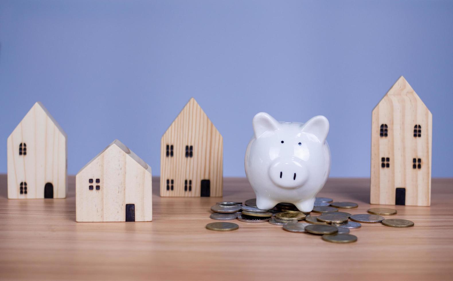 A white piggy bank is placed on a pile of coins. photo