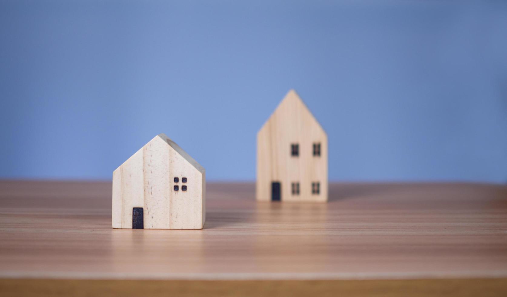 Two wooden model houses placed on a wooden table. photo