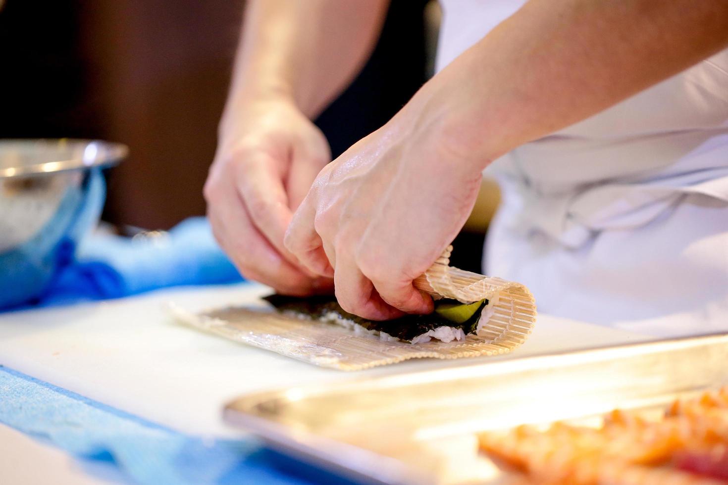 manos de chef preparando comida japonesa, chef haciendo sushi foto