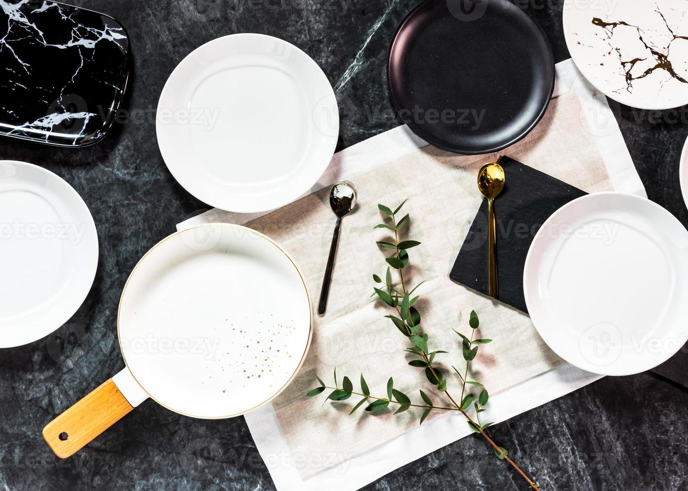 Juego de cena sobre un fondo oscuro, plato blanco vacío con tenedor y cuchara foto