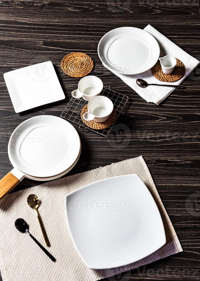 Juego de cena sobre un fondo oscuro, plato blanco vacío con tenedor y cuchara foto