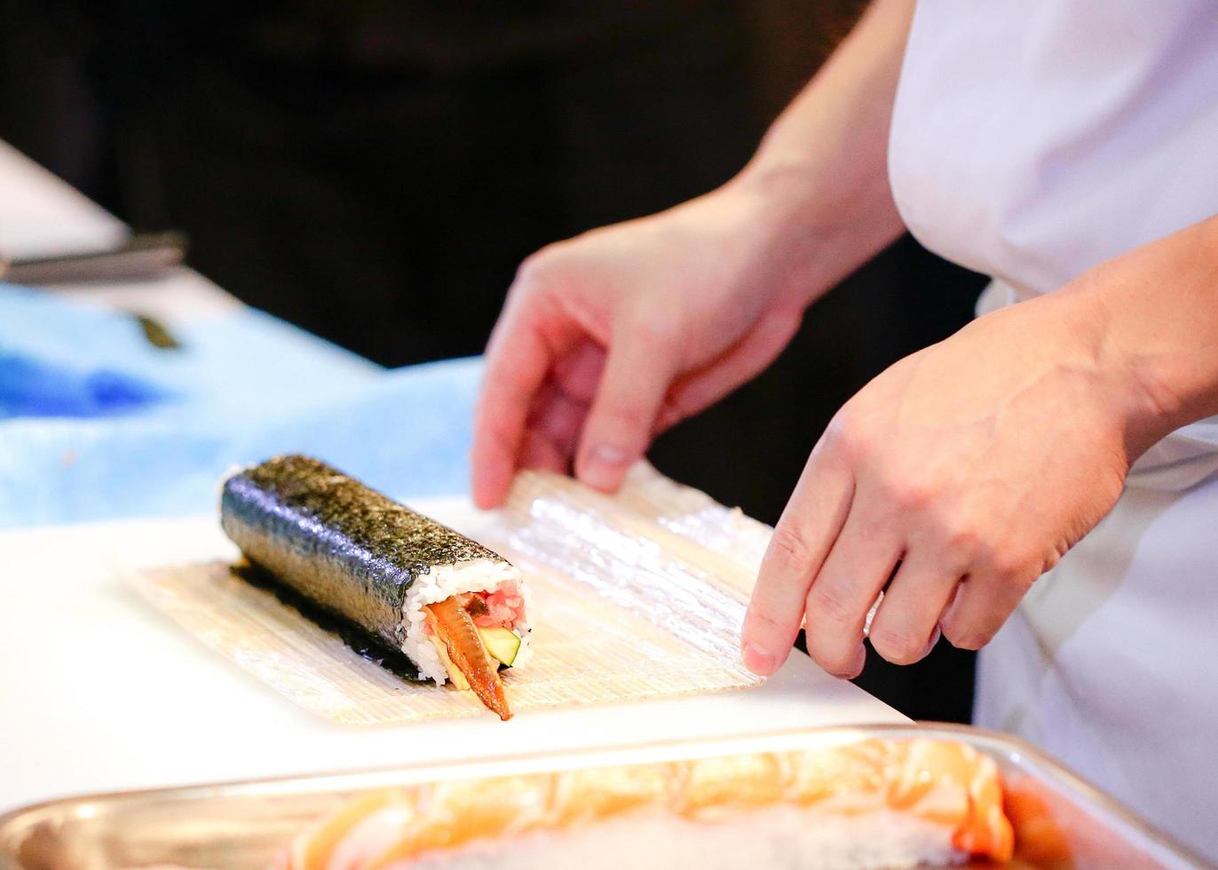 manos de chef preparando comida japonesa, chef haciendo sushi foto