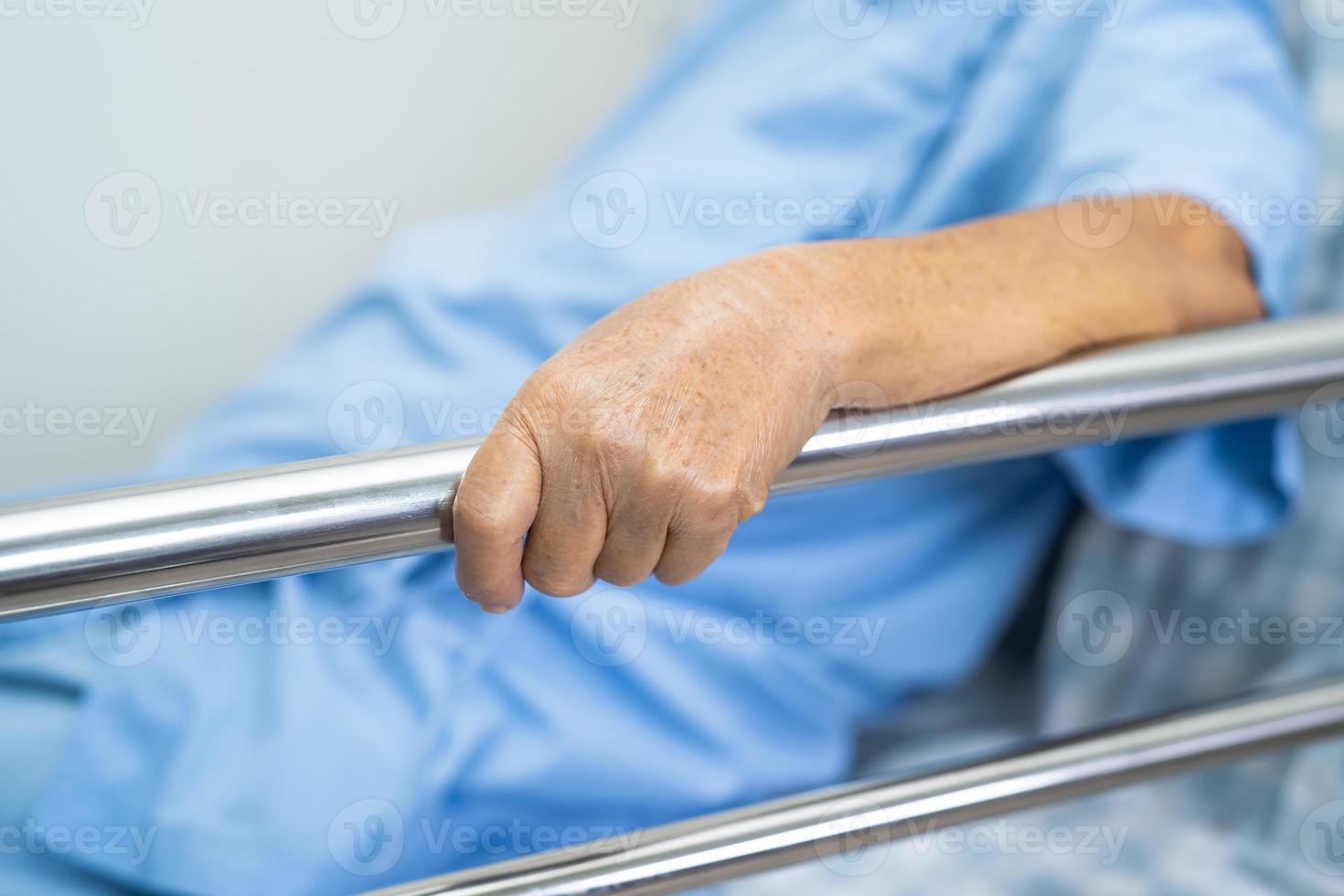 Asian senior woman patient lie down handle the rail bed photo