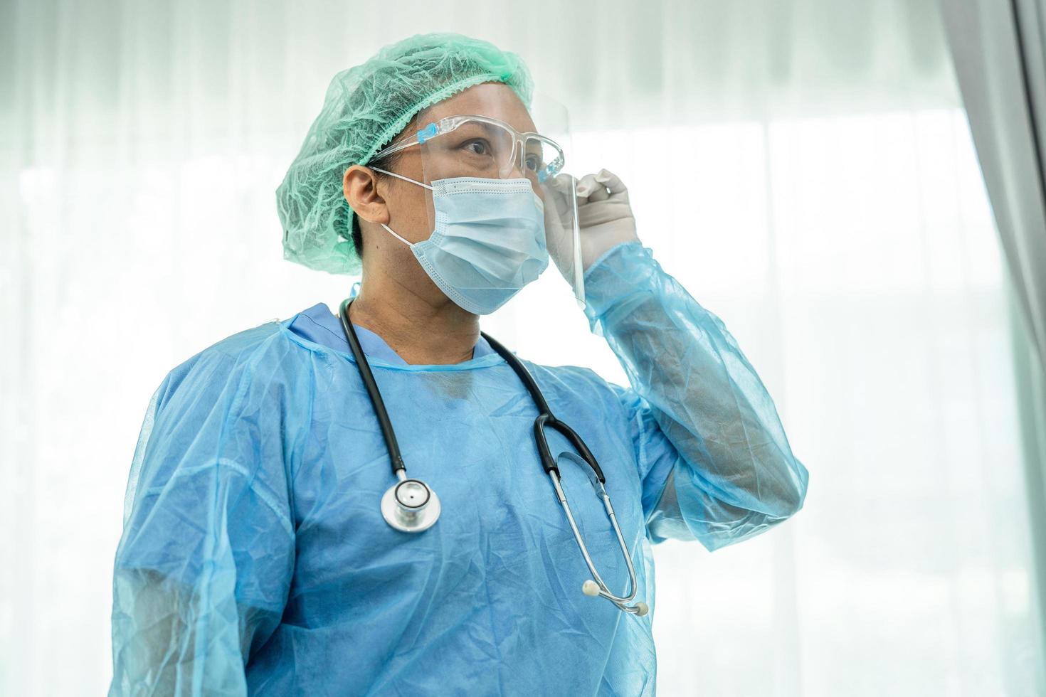 Asian doctor wearing face shield and PPE suit protect Coronavirus photo