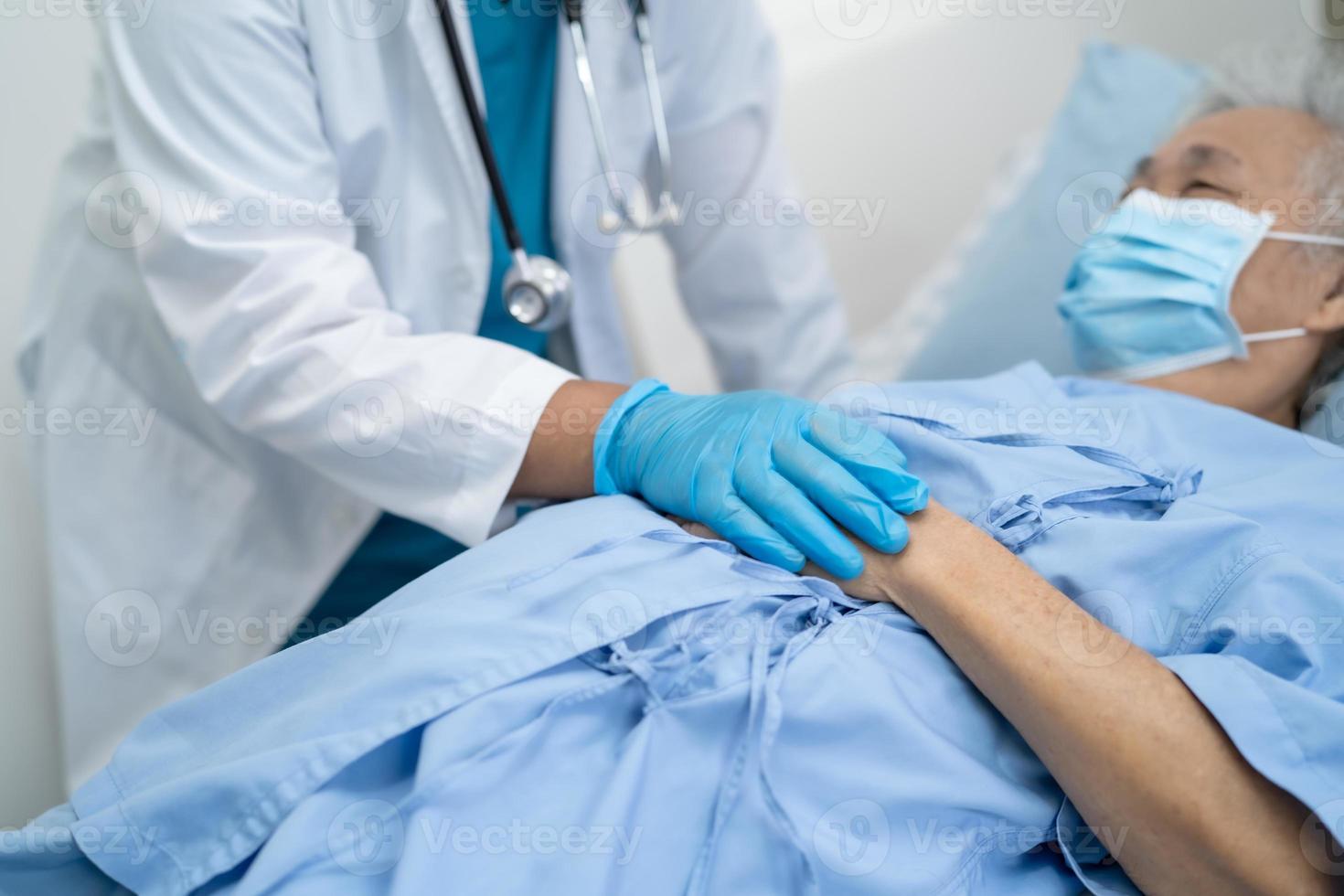 médico que controla a la mujer mayor asiática del paciente en la sala del hospital de enfermería. foto