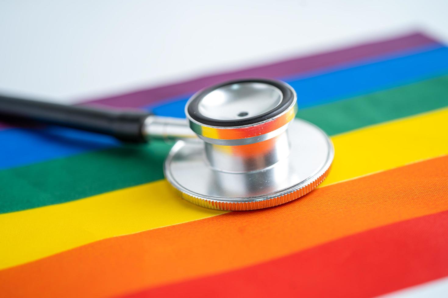 estetoscopio negro en la bandera del arco iris, símbolo del mes del orgullo lgbt foto