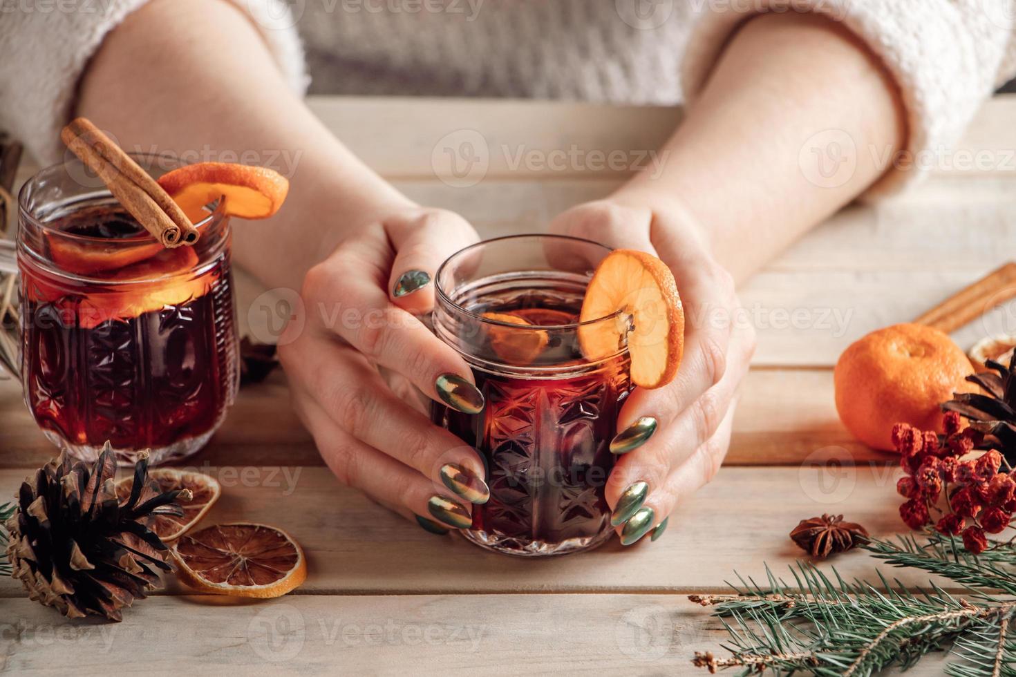 mujer sostiene una taza de vino caliente caliente en sus manos. foto