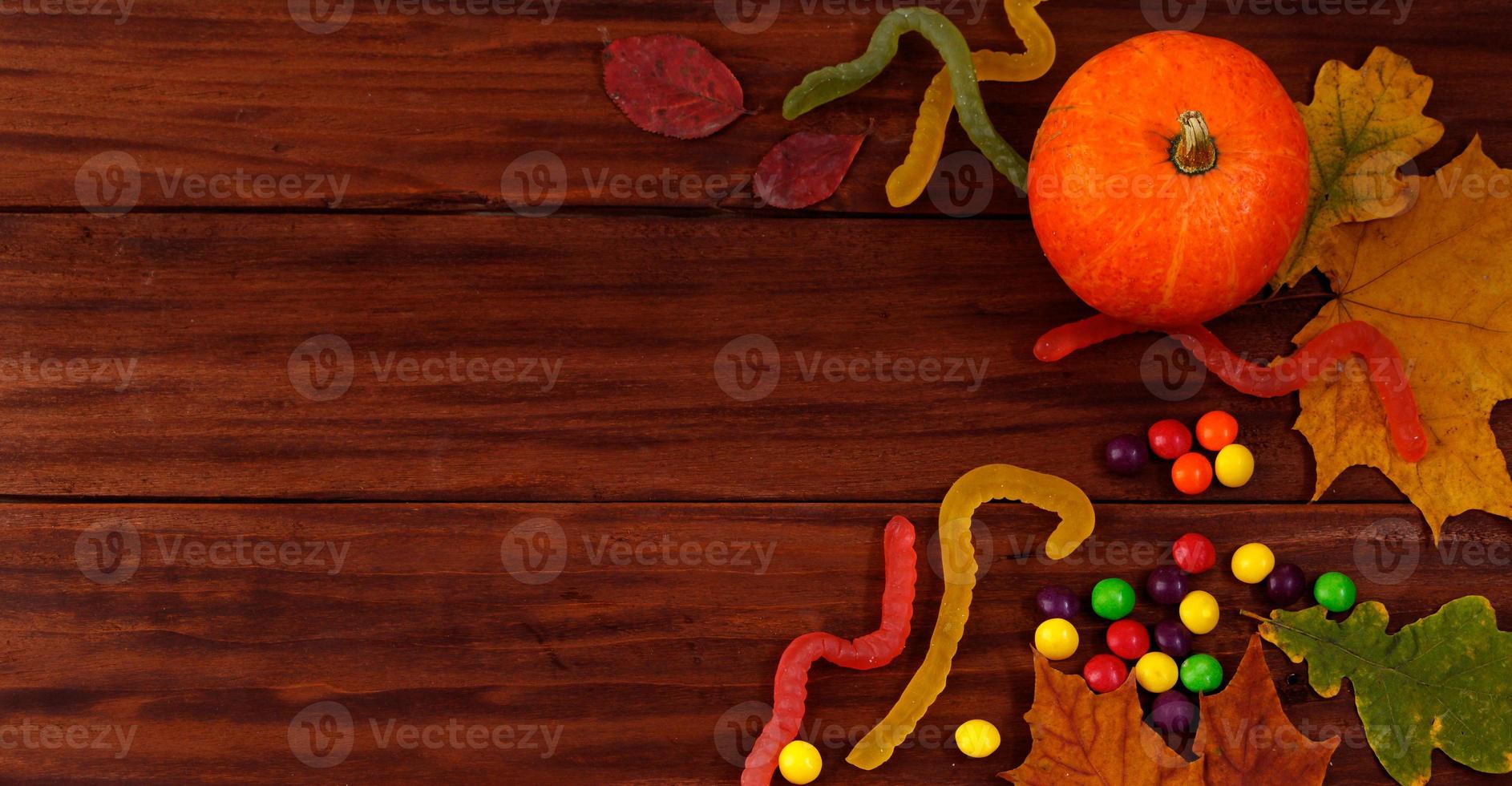 Halloween sweets. Pumpkins, autumn leaves and candies photo