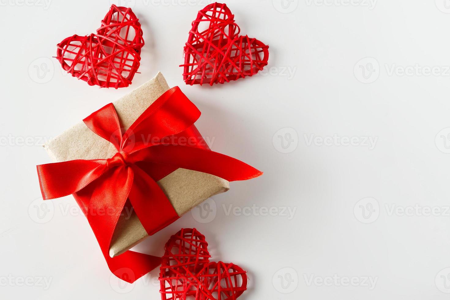 regalo del día de san valentín y corazones rojos sobre un fondo blanco foto