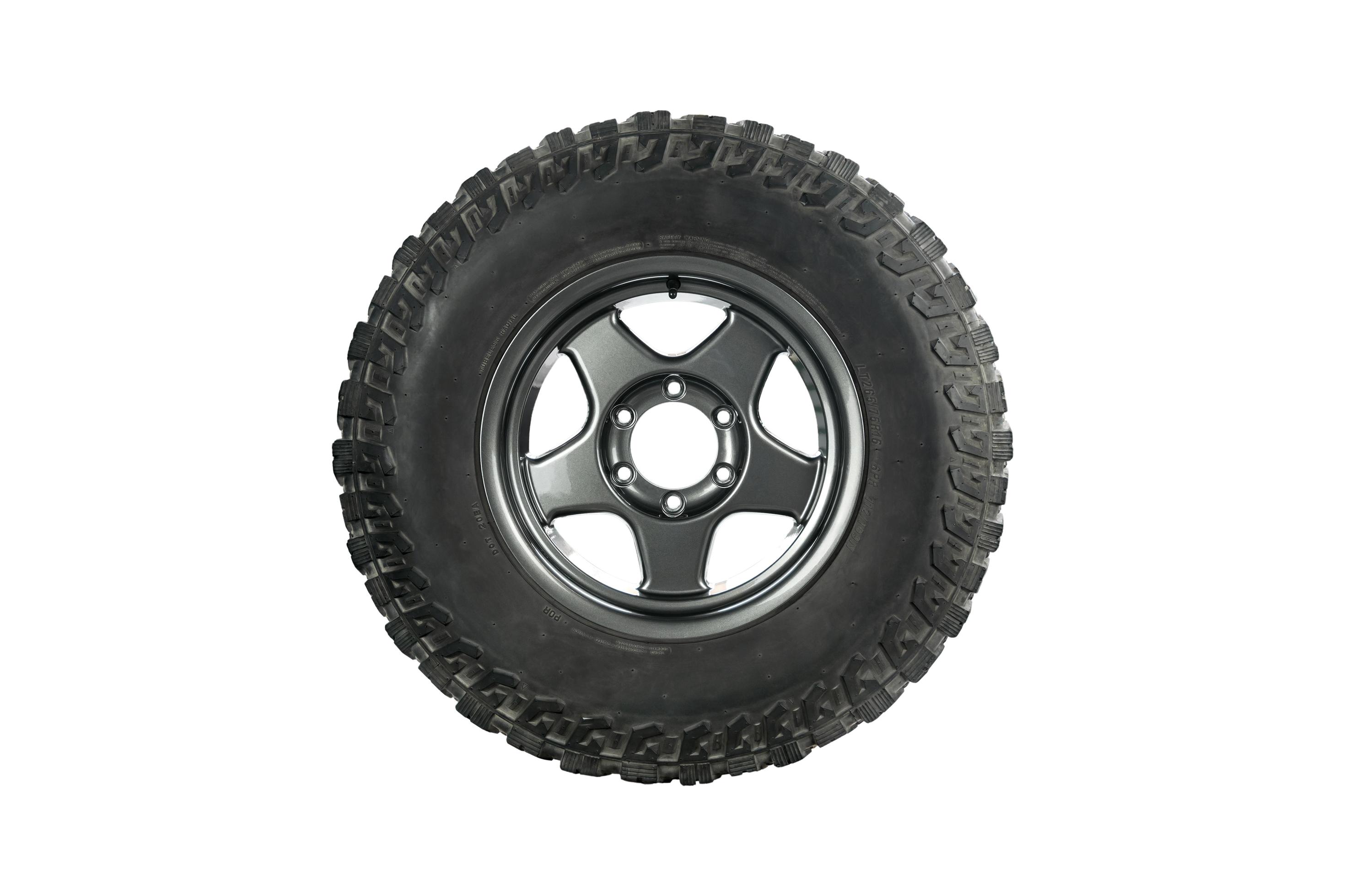 Side view of an all terrain tire with alloy wheel on white background