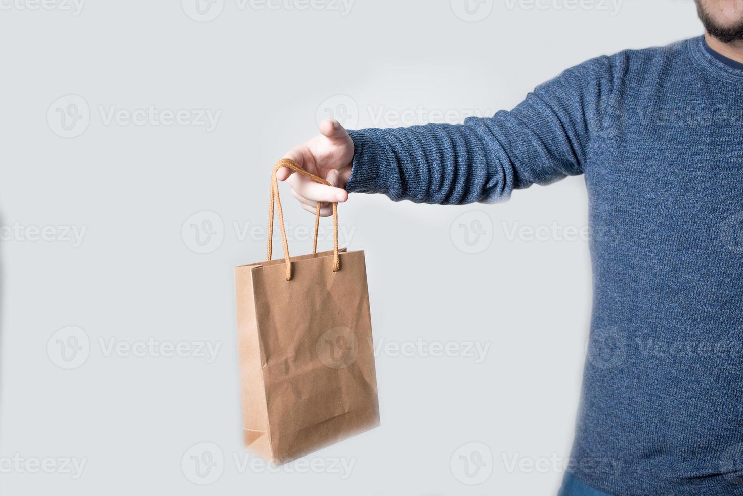 Young anonymous man holding a paper bag photo