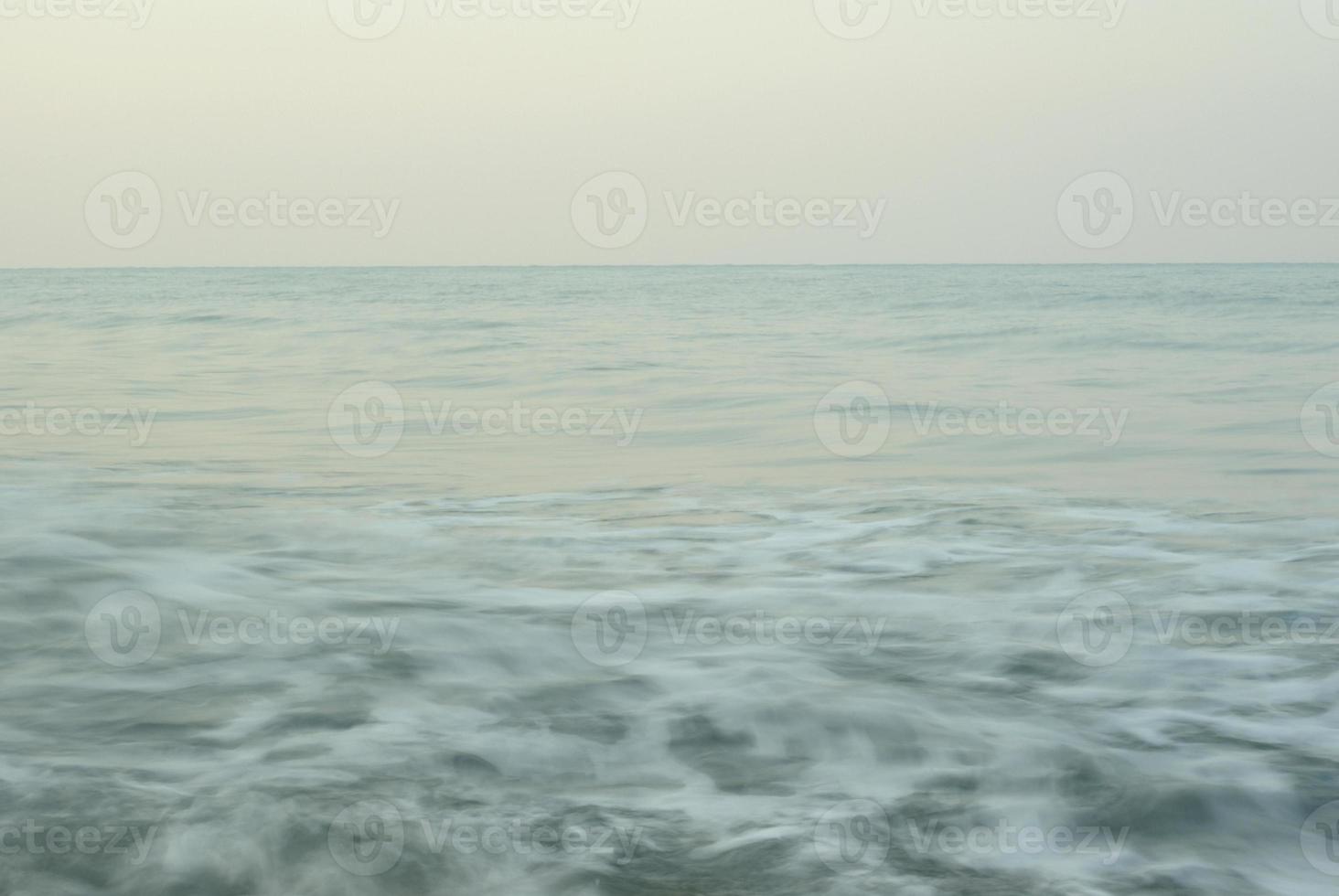 turbulencia de agua de mar y rocas en la costa foto