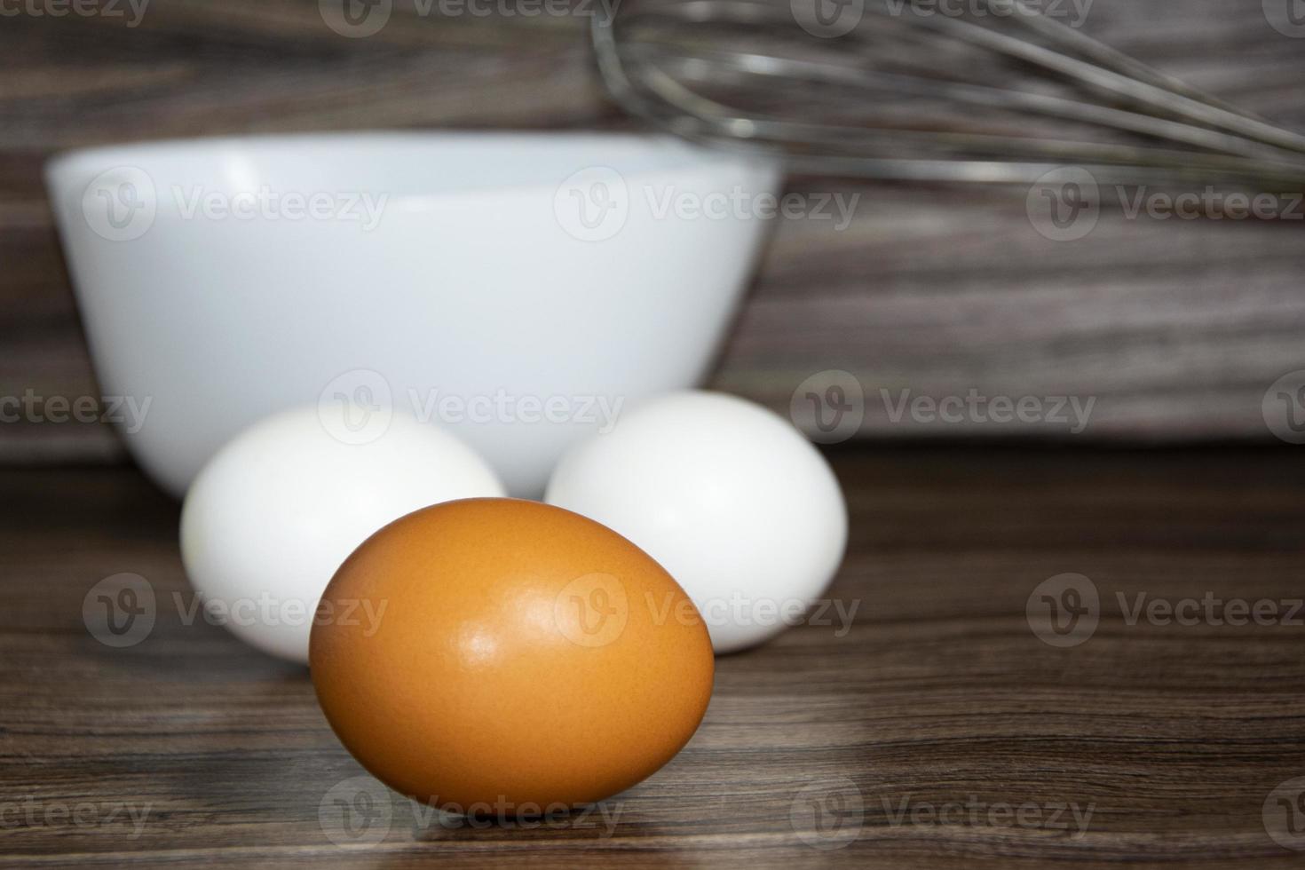 Chicken eggs on a wooden table. White and orange eggs. photo