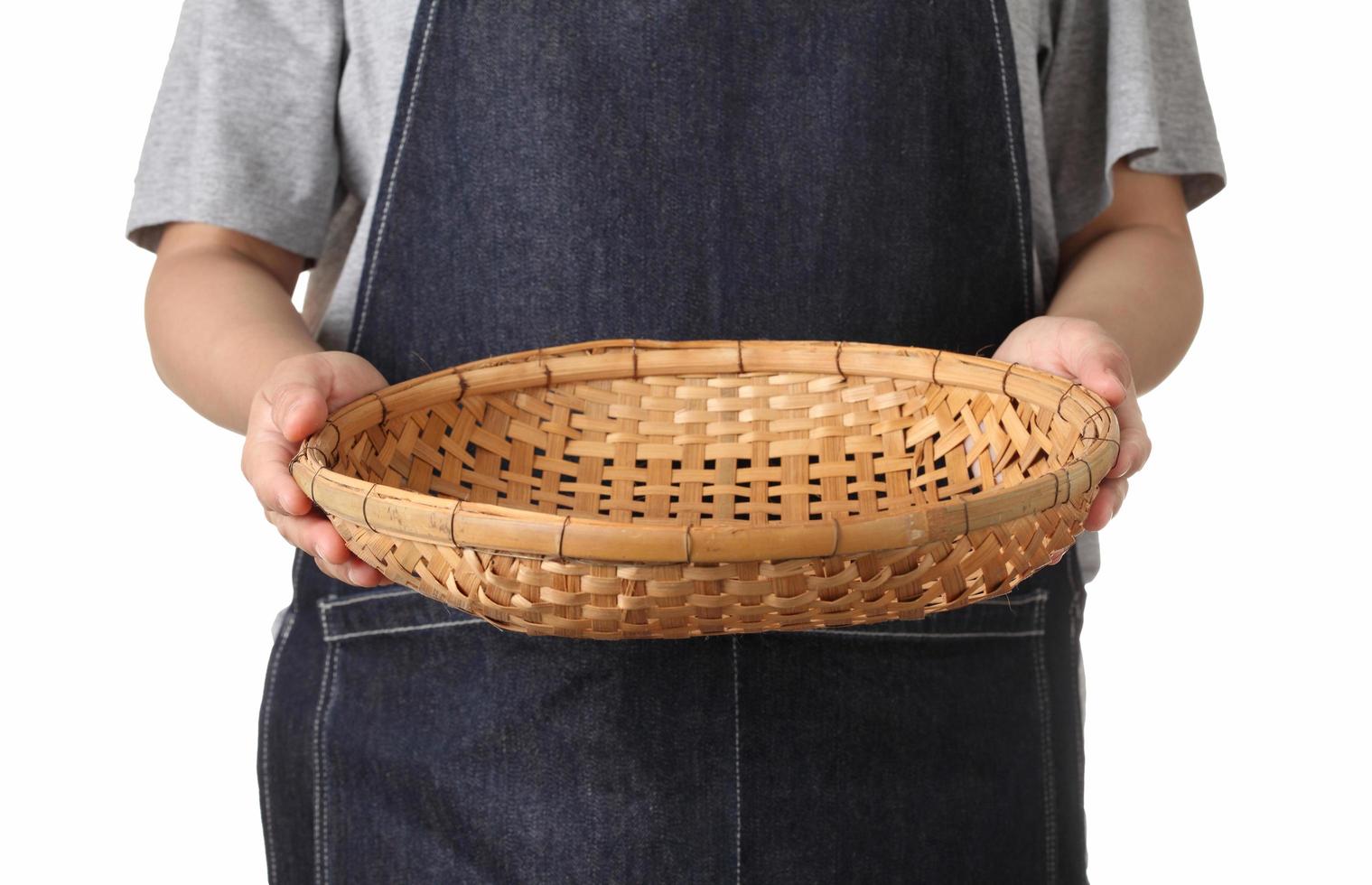 Chef sosteniendo una cesta de madera sobre fondo blanco. foto